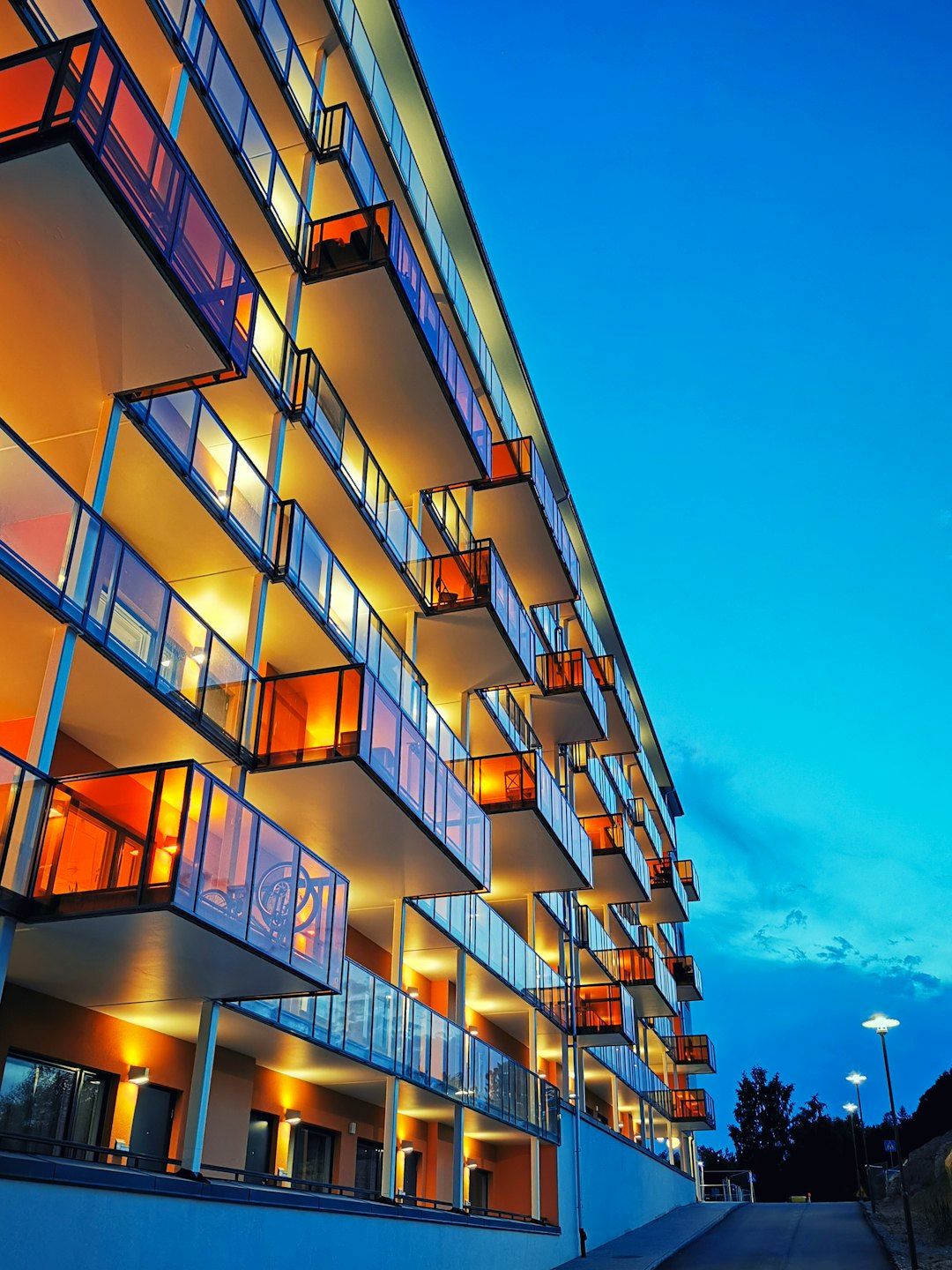 Palazzo moderno con finestre illuminate al tramonto.